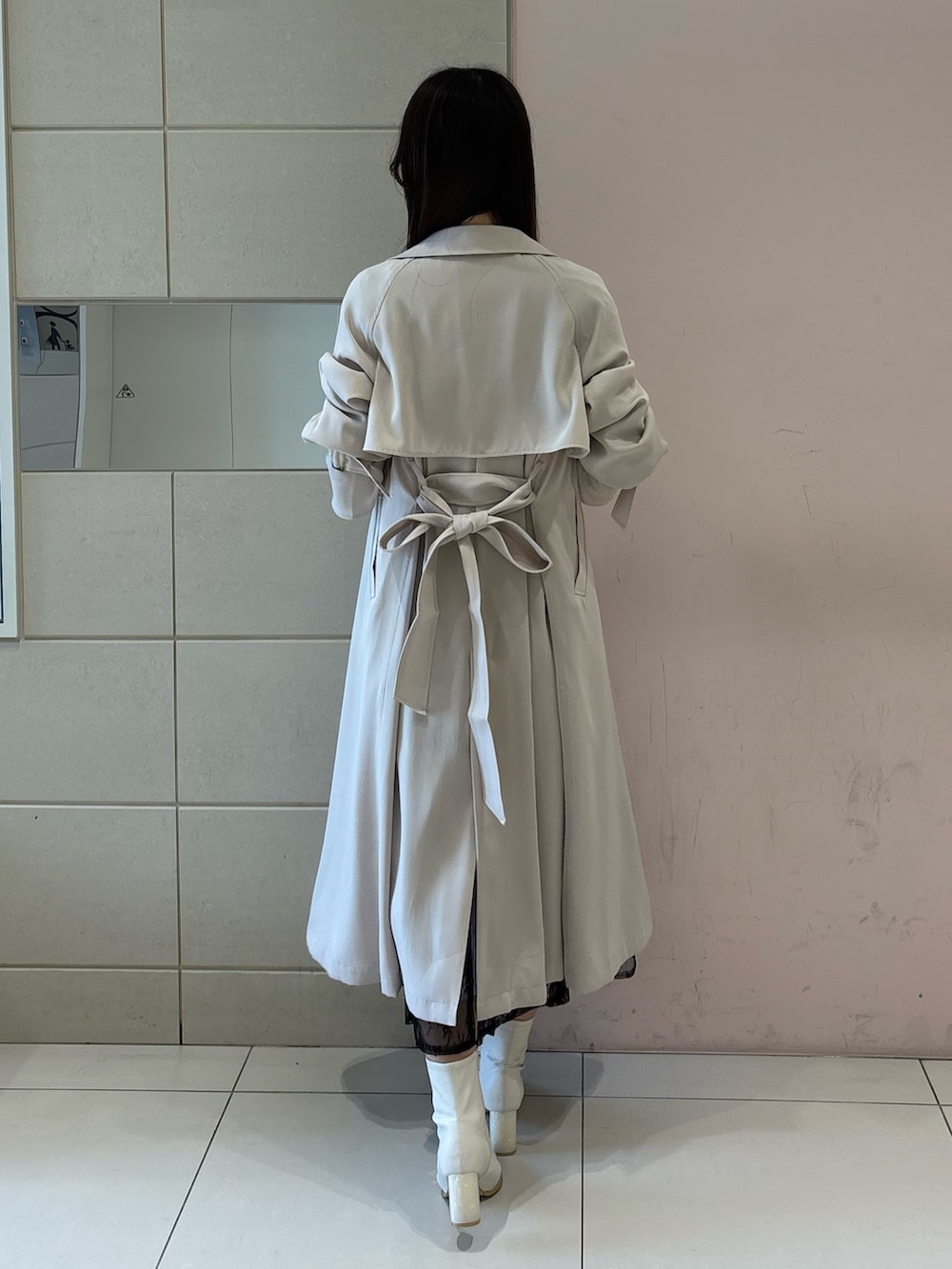 ブルー系のワンピース、ホワイト系のトレンチコート、ホワイト系のブーツを着用したレディースの冬コーディネートの5枚目の写真