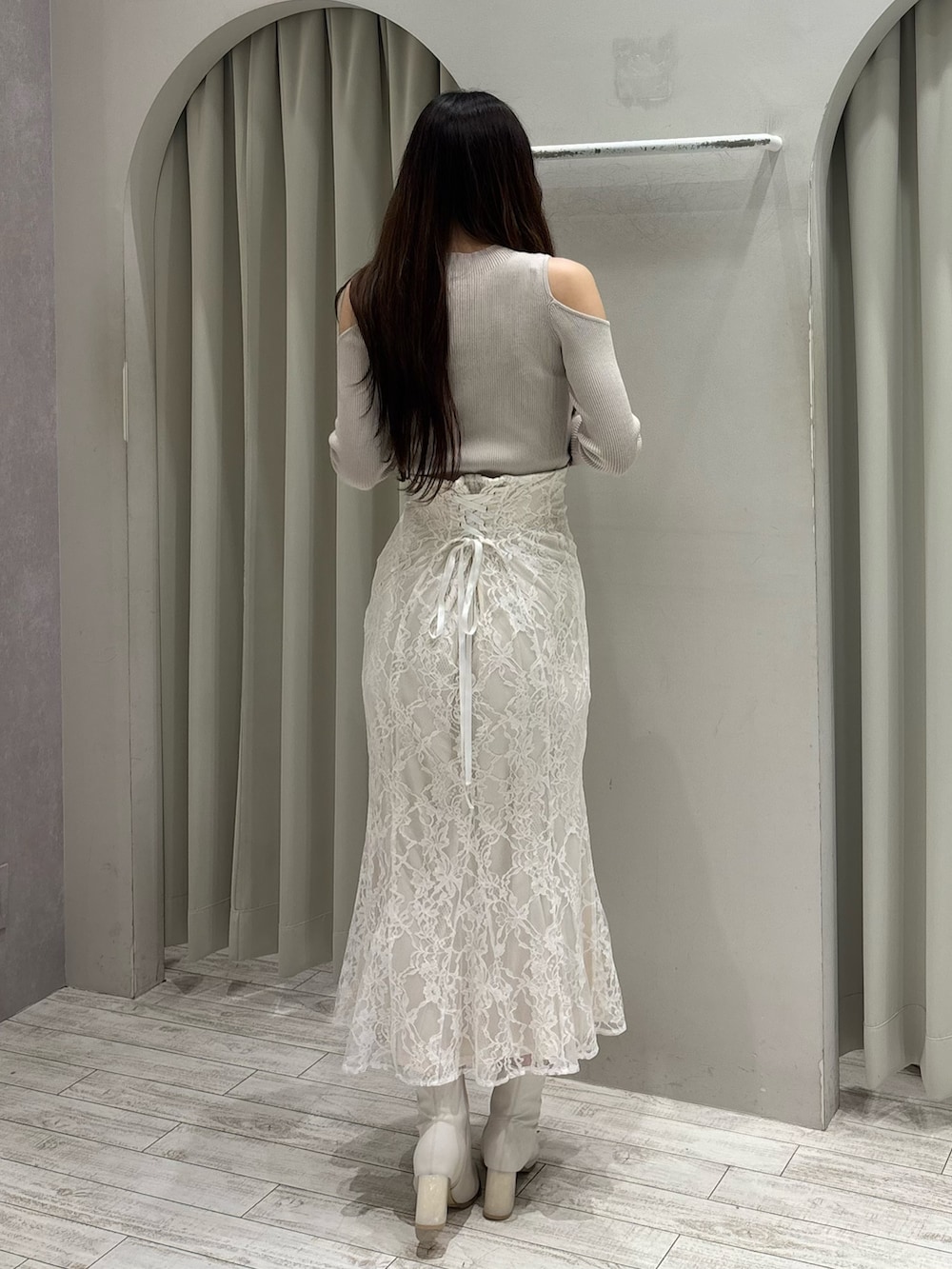 ベージュ系のニット/セーター、ホワイト系のスカート、ホワイト系のブーツを着用したレディースの春コーディネートの7枚目の写真