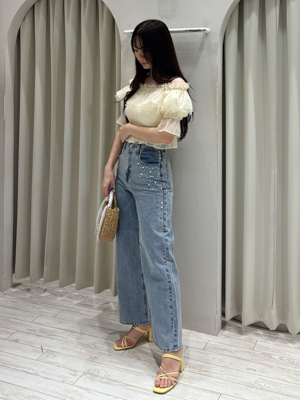 ホワイト系のシャツ/ブラウス、ブルー系のデニムパンツ、ベージュ系のハンドバッグを着用したレディースの夏コーディネートの2枚目の写真