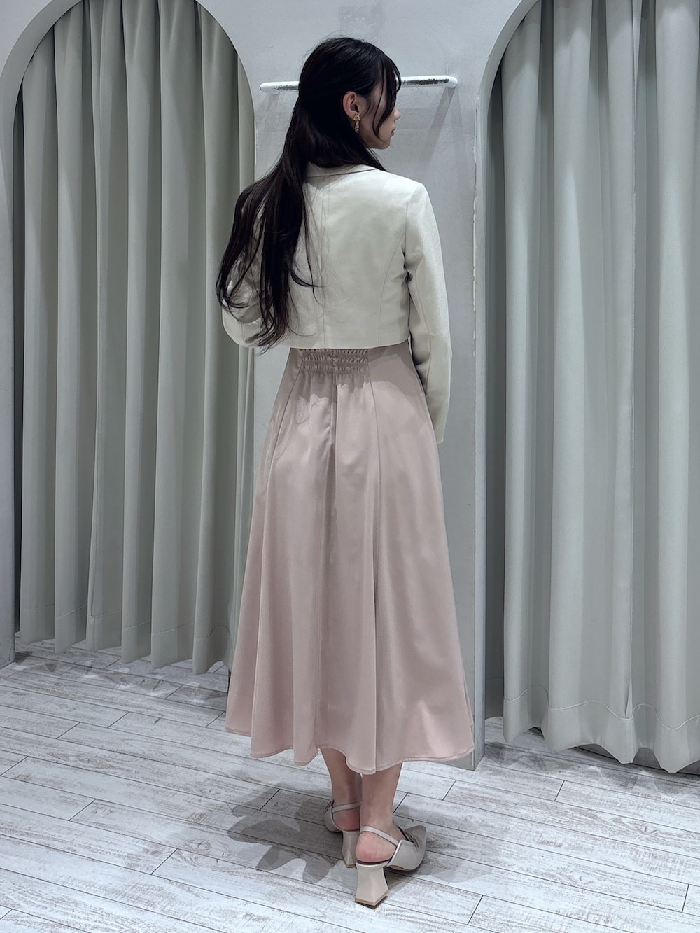 ピンク系のドレス、ホワイト系のテーラードジャケット、ゴールド系のショルダーバッグを着用したレディースの春コーディネートの5枚目の写真