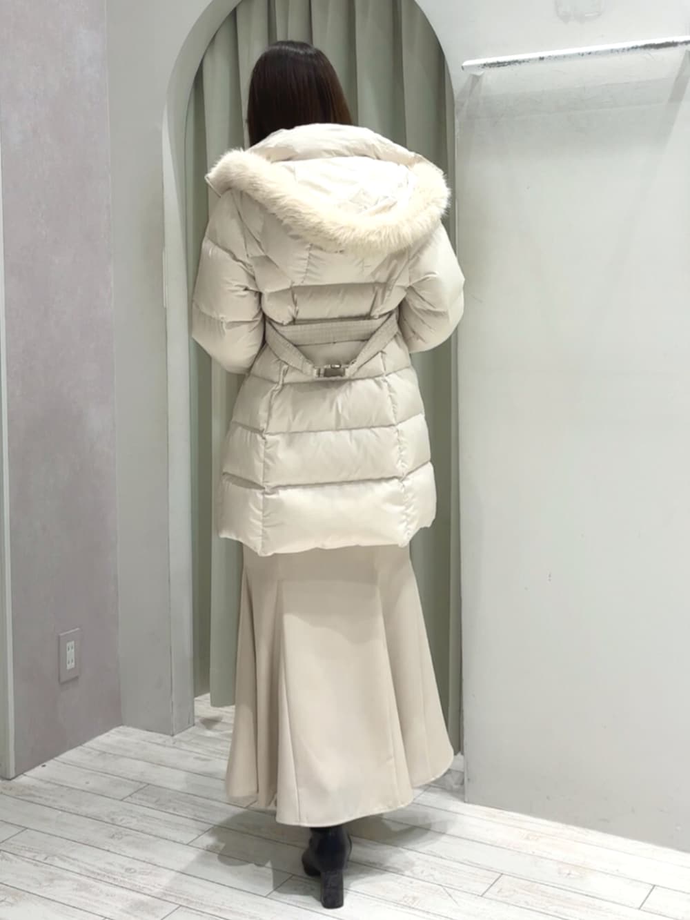 ホワイト系のハンドバッグ、ブラック系のブーツ、ホワイト系のダウンジャケット/コートを着用したレディースの秋コーディネートの4枚目の写真