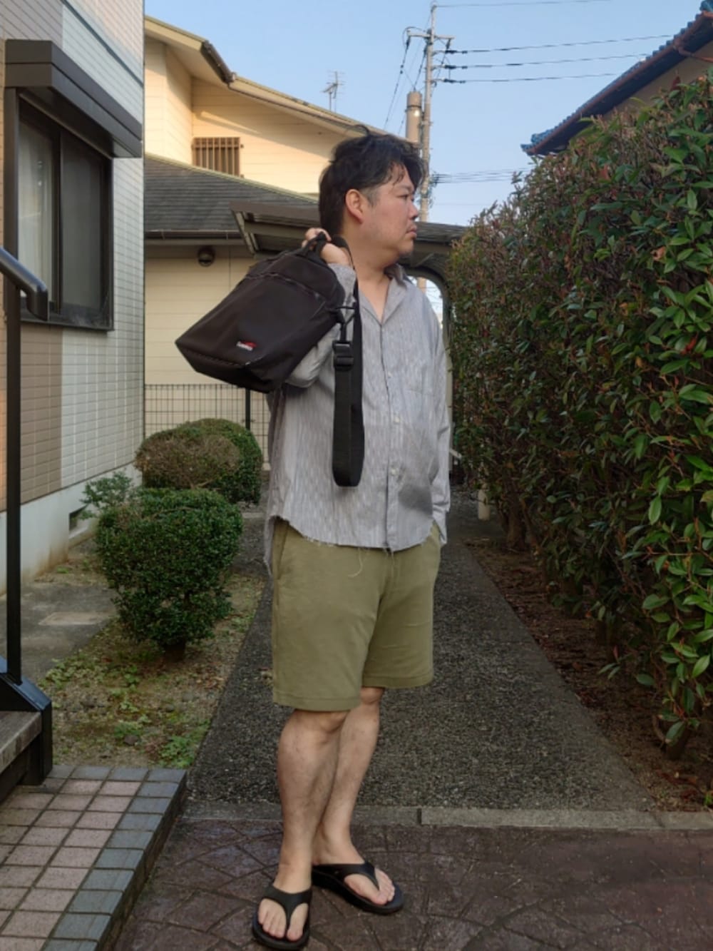 ブルー系のシャツ/ブラウス、グリーン系のパンツ、ブラック系のサンダルを着用したメンズの夏コーディネートの2枚目の写真