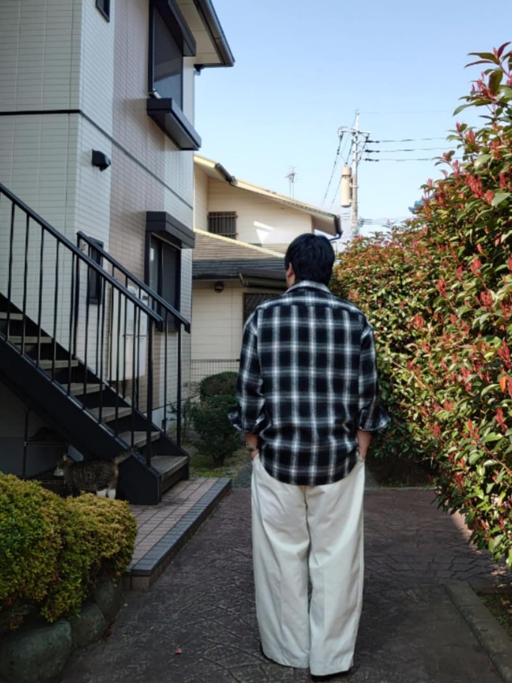 ブラック系のシャツ/ブラウス、ホワイト系のスラックス、ブラック系のドレスシューズを着用したメンズの春コーディネートの3枚目の写真