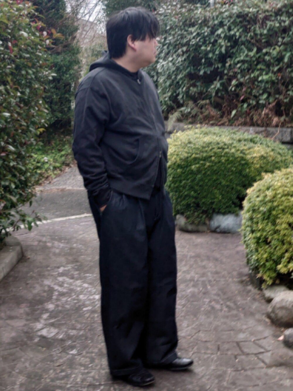 ブラック系のパーカー、ブラック系のTシャツ/カットソー、ブルー系のデニムパンツを着用したメンズの春コーディネートの2枚目の写真