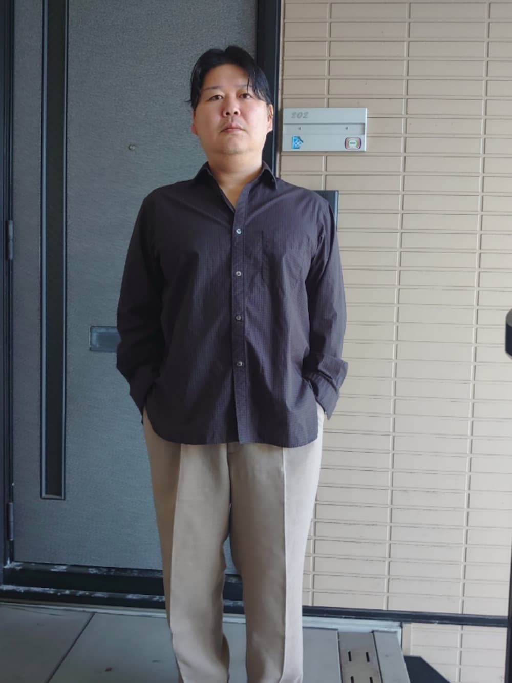 グレー系のシャツ/ブラウス、ベージュ系のスラックスを着用したメンズの春コーディネートの2枚目の写真