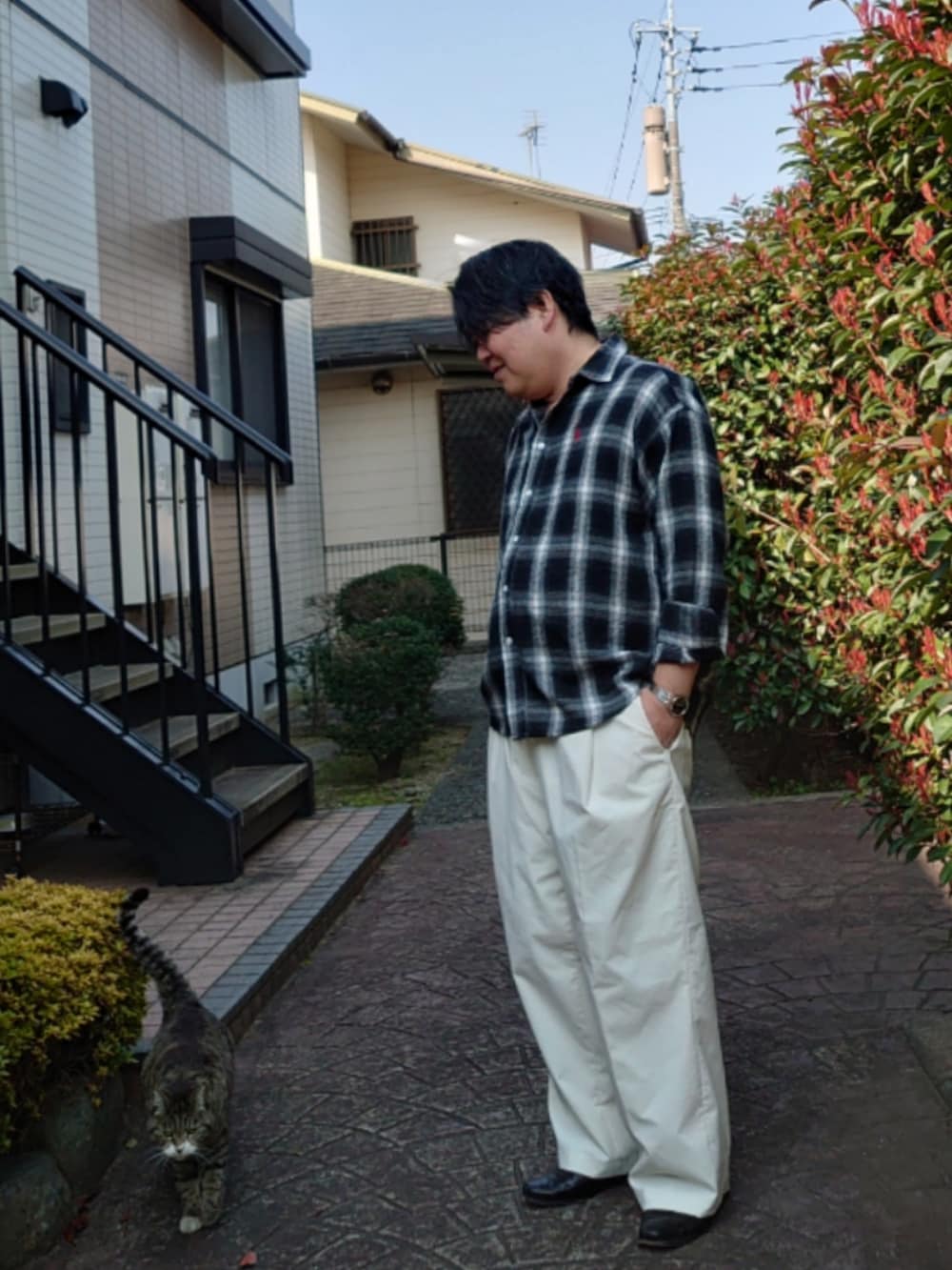 ブラック系のシャツ/ブラウス、ホワイト系のスラックス、ブラック系のドレスシューズを着用したメンズの春コーディネートの2枚目の写真