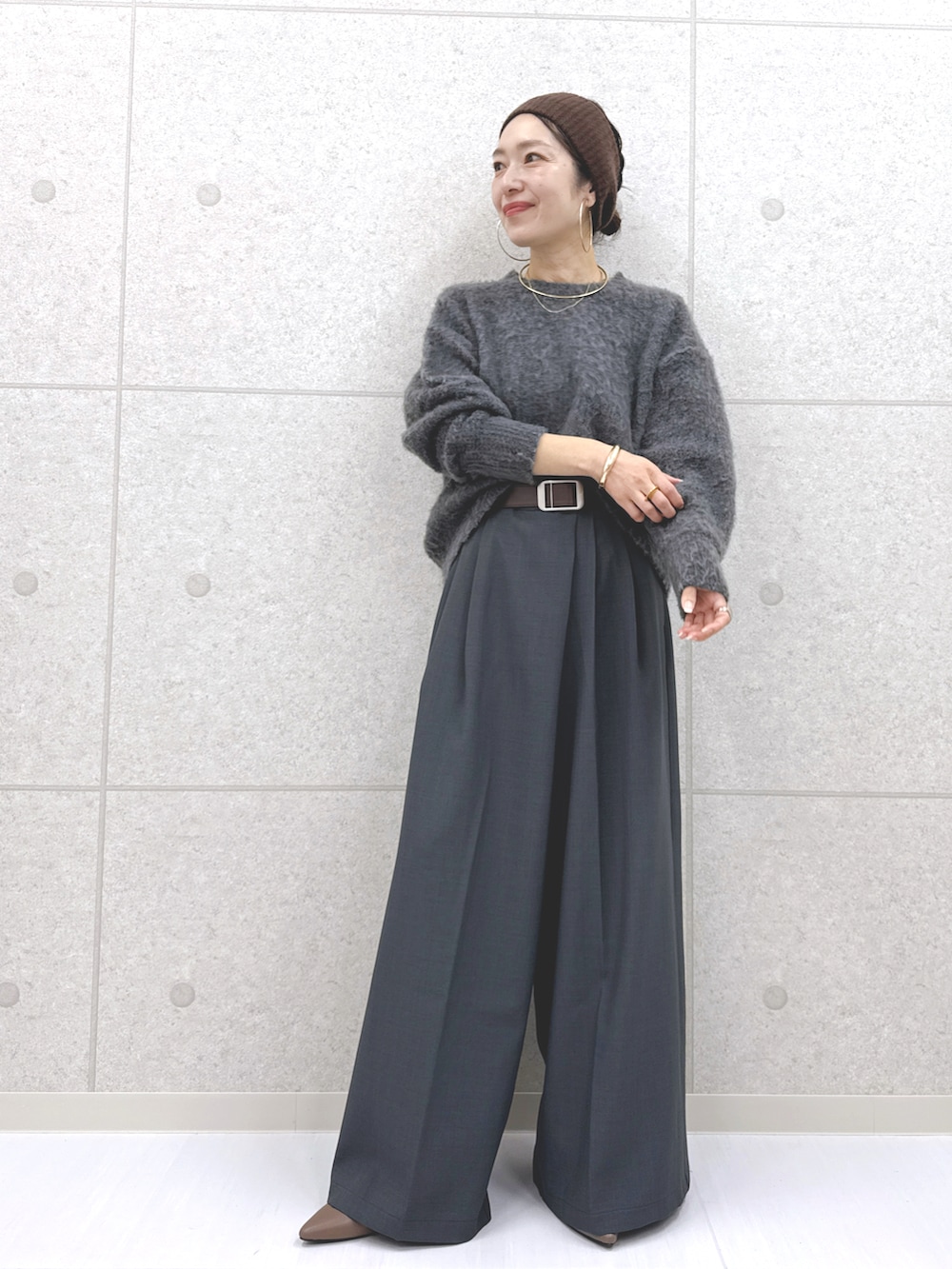 グレー系のその他パンツ、グレー系のニット/セーター、ブルー系のシャツ/ブラウスを着用したレディースの秋コーディネートの2枚目の写真