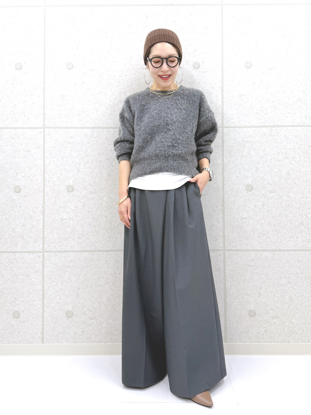 グレー系のその他パンツ、グレー系のニット/セーター、ブルー系のシャツ/ブラウスを着用したレディースの秋コーディネートの3枚目の写真