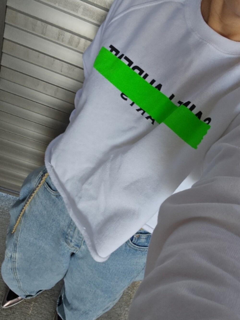 ホワイト系のスウェット、ブルー系のデニムパンツを着用したレディースの秋コーディネートの2枚目の写真