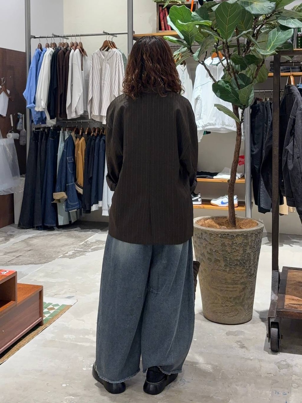 ベージュ系のTシャツ/カットソー、ブルー系のデニムパンツ、ブラウン系のテーラードジャケットを着用したレディースの秋コーディネートの3枚目の写真