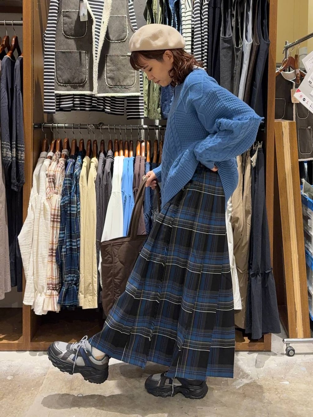 ブラック系のスカート、ホワイト系のTシャツ/カットソー、グレー系のスニーカーを着用したレディースの秋コーディネートの2枚目の写真