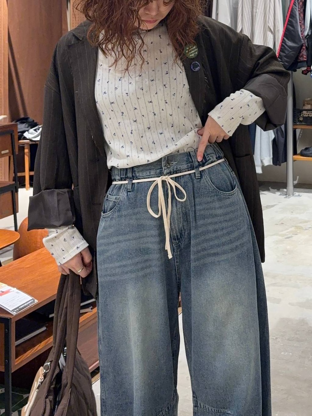 ベージュ系のTシャツ/カットソー、ブルー系のデニムパンツ、ブラウン系のテーラードジャケットを着用したレディースの秋コーディネートの6枚目の写真