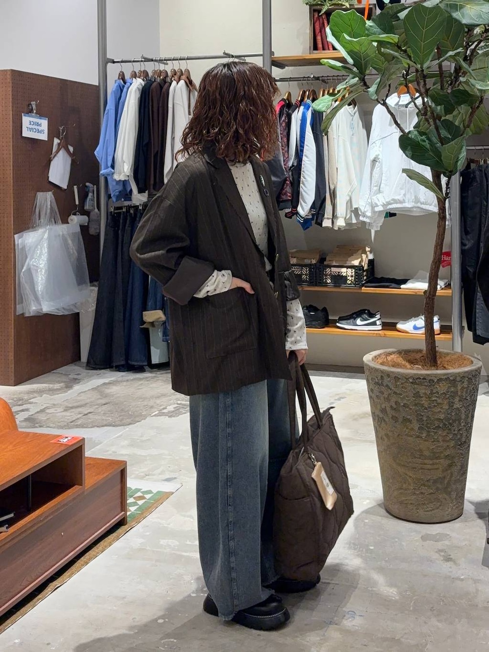 ベージュ系のTシャツ/カットソー、ブルー系のデニムパンツ、ブラウン系のテーラードジャケットを着用したレディースの秋コーディネートの2枚目の写真