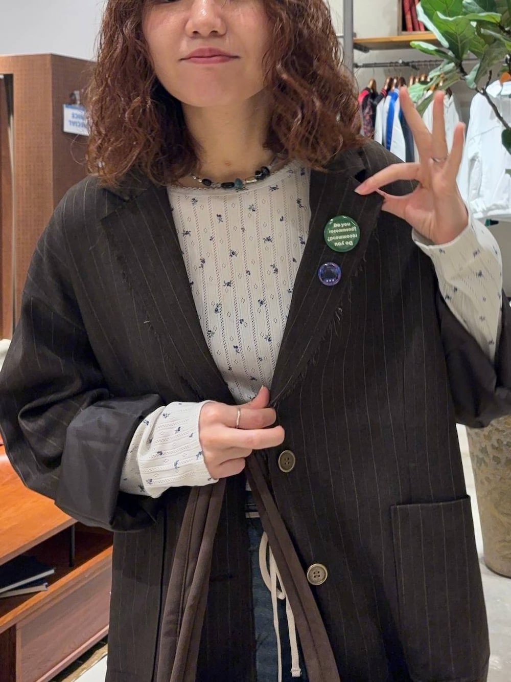 ベージュ系のTシャツ/カットソー、ブルー系のデニムパンツ、ブラウン系のテーラードジャケットを着用したレディースの秋コーディネートの5枚目の写真