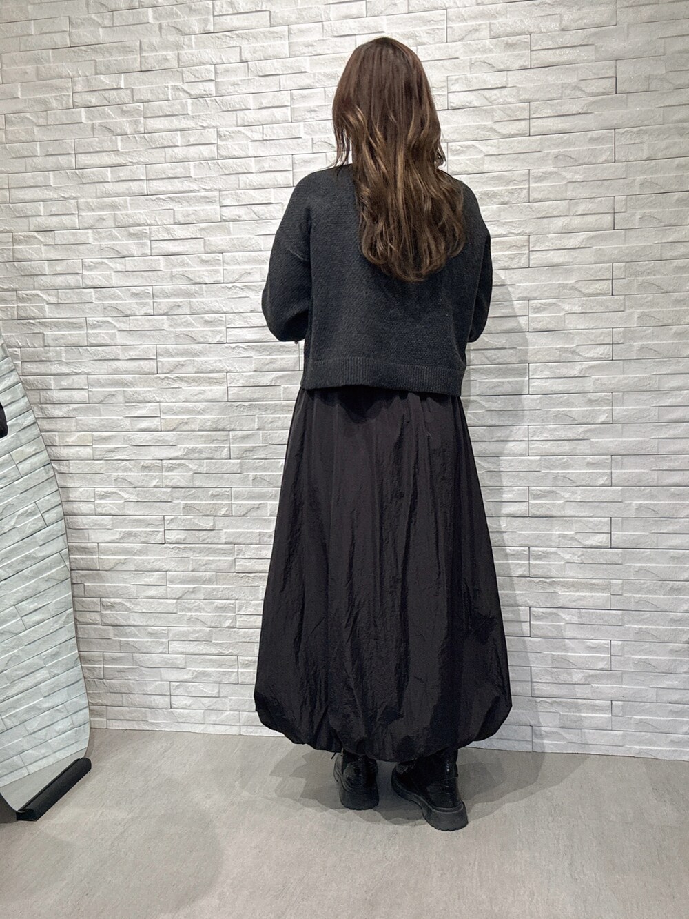 グレー系のニット/セーター、ブラック系のスカートを着用したレディースの冬コーディネートの3枚目の写真