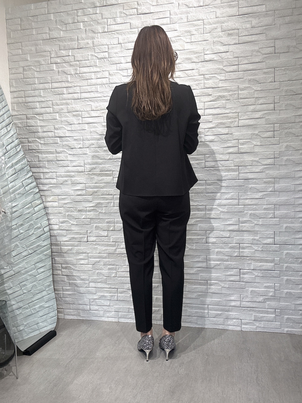 ブラック系のシャツ/ブラウス、ブラック系のスラックスを着用したレディースの冬コーディネートの2枚目の写真