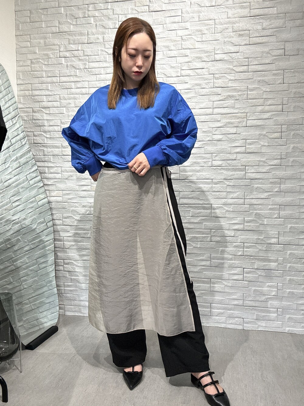 ブルー系のシャツ/ブラウス、ベージュ系のスカート、ブラック系のその他パンツを着用したレディースの春コーディネートの2枚目の写真