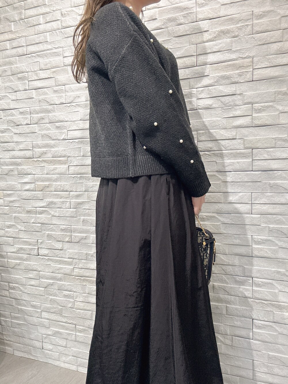 グレー系のニット/セーター、ブラック系のスカートを着用したレディースの冬コーディネートの4枚目の写真