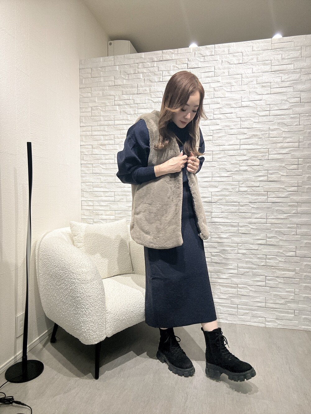 ブルー系のニット/セーター、ベージュ系のベストを着用したレディースの秋コーディネートの2枚目の写真