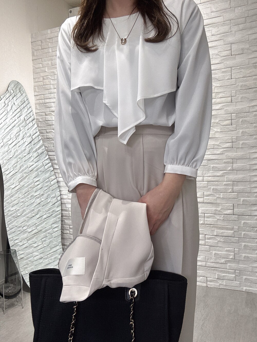 ベージュ系のセットアップ、ホワイト系のシャツ/ブラウス、ベージュ系のスラックスを着用したレディースの冬コーディネートの3枚目の写真