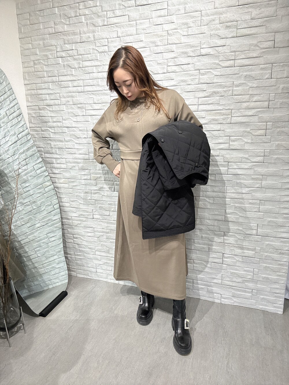 ブラック系のノーカラーコート、グリーン系のワンピースを着用したレディースの冬コーディネートの4枚目の写真