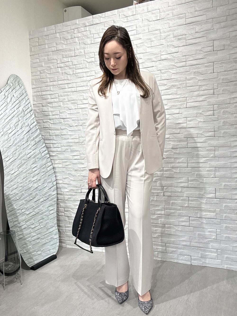 ベージュ系のセットアップ、ホワイト系のシャツ/ブラウス、ベージュ系のスラックスを着用したレディースの冬コーディネートの2枚目の写真