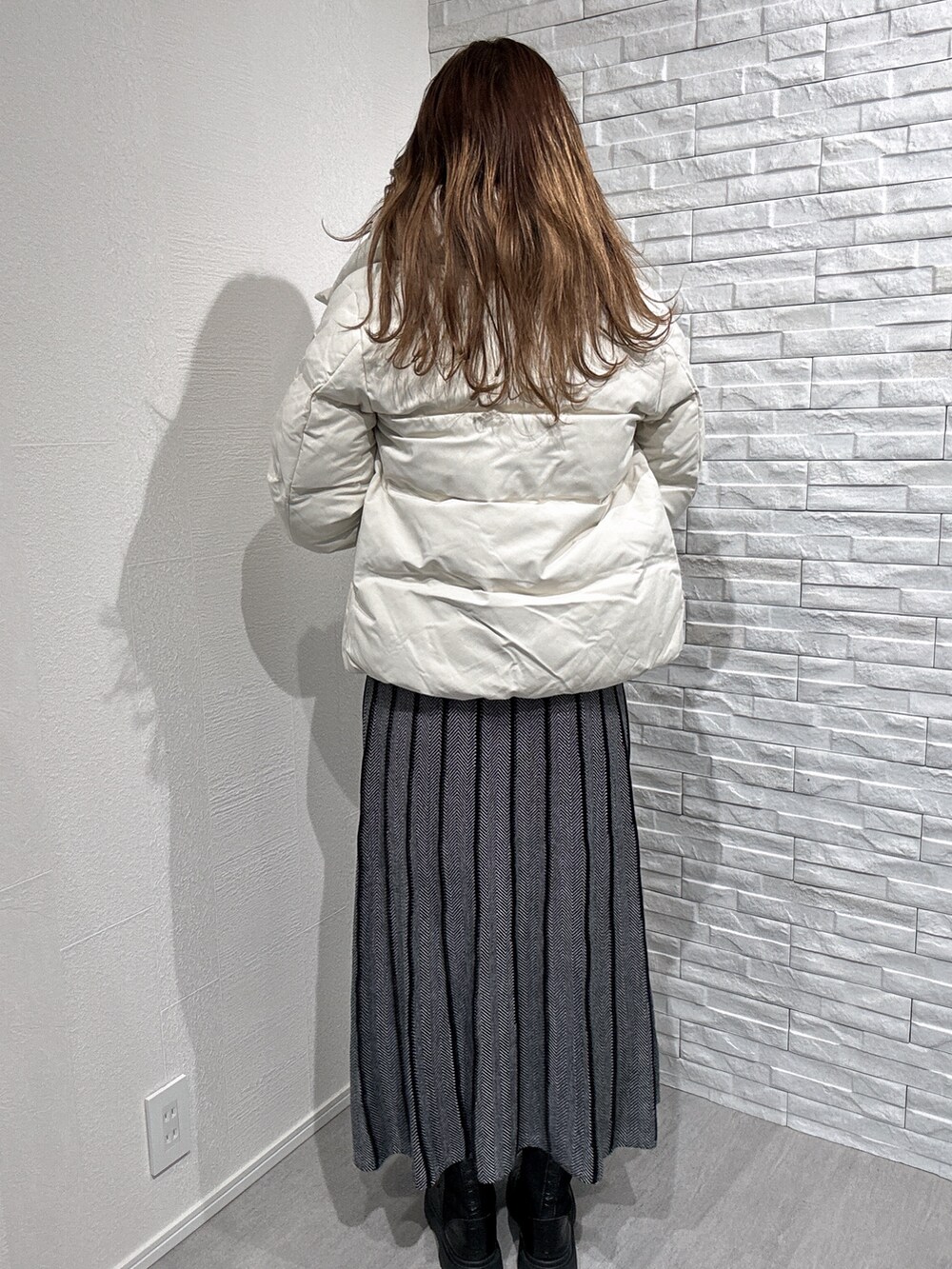 ホワイト系のダウンジャケット/コート、ブラック系のニット/セーターを着用したレディースの秋コーディネートの3枚目の写真