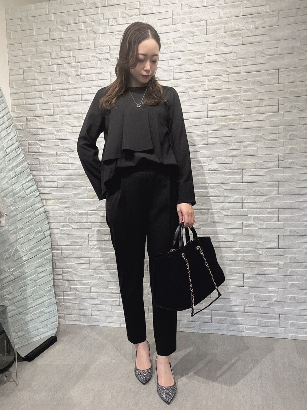 ブラック系のシャツ/ブラウス、ブラック系のスラックスを着用したレディースの冬コーディネートの4枚目の写真
