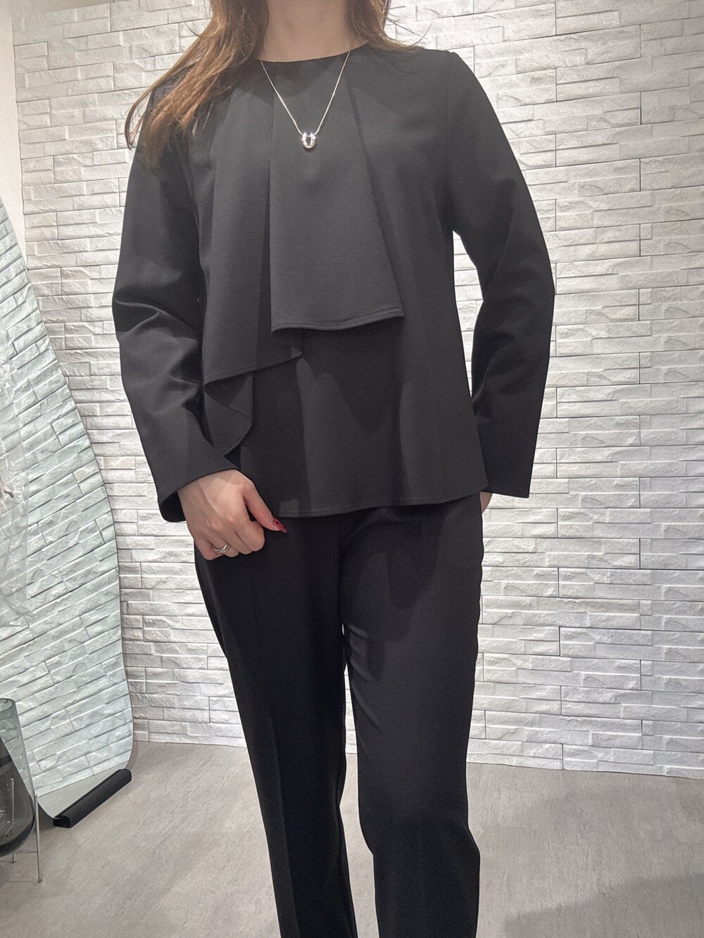 ブラック系のシャツ/ブラウス、ブラック系のスラックスを着用したレディースの冬コーディネートの3枚目の写真