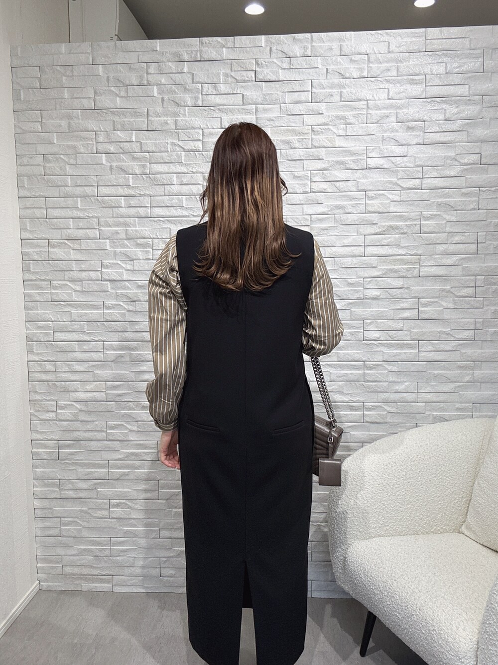 ブラック系のワンピース、ベージュ系のシャツ/ブラウスを着用したレディースの秋コーディネートの2枚目の写真