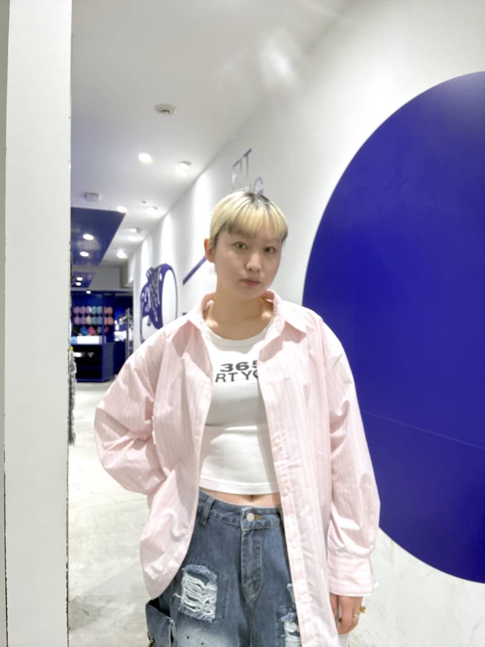 ピンク系のシャツ/ブラウス、ブルー系のデニムパンツを着用したレディースの春コーディネートの4枚目の写真