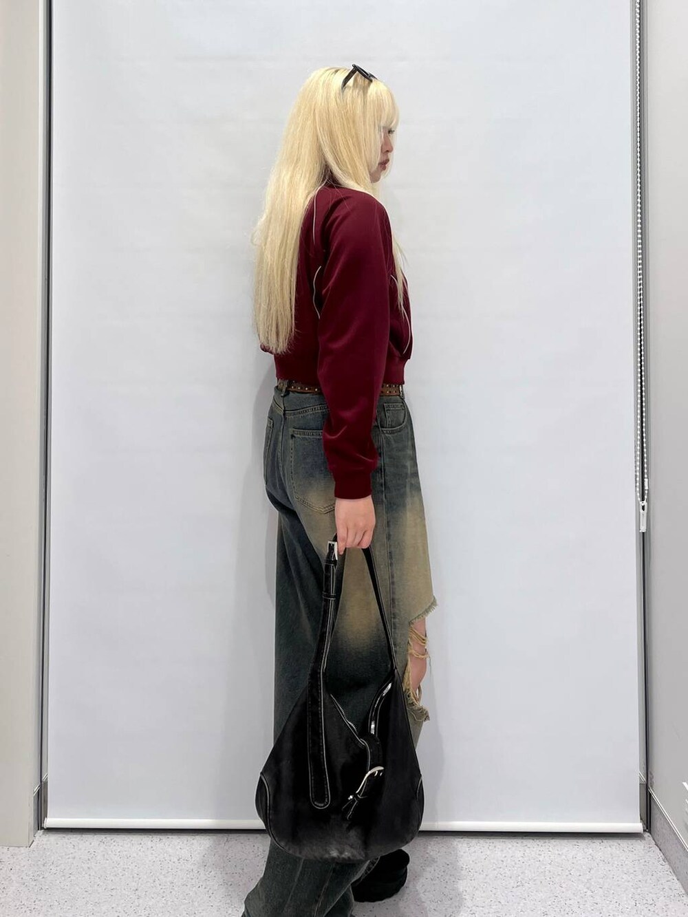 ブルー系のデニムパンツ、ブラック系のショルダーバッグ、レッド系のブルゾンを着用したレディースの夏コーディネートの3枚目の写真