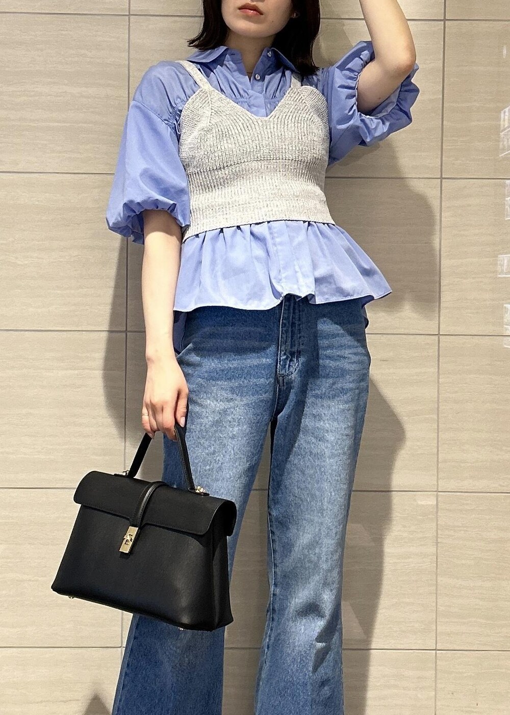 ブラック系のハンドバッグ、ブルー系のデニムパンツ、ブラック系のサンダルを着用したレディースの春コーディネートの10枚目の写真