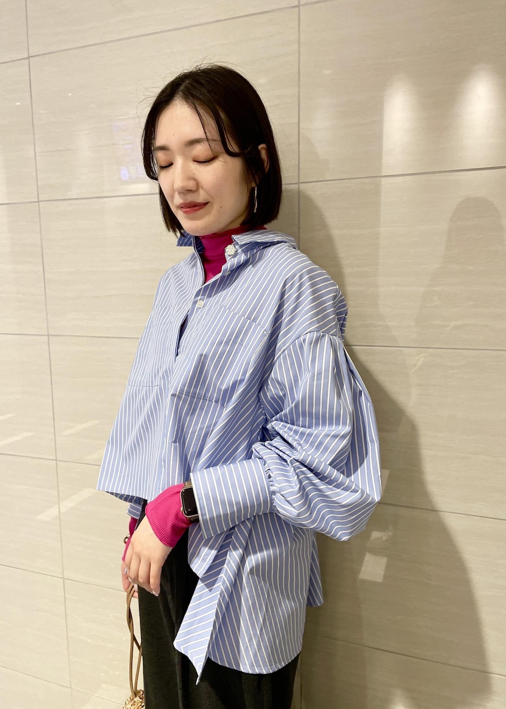 ピンク系のTシャツ/カットソー、ゴールド系のハンドバッグ、グレー系のスラックスを着用したレディースの冬コーディネートの4枚目の写真