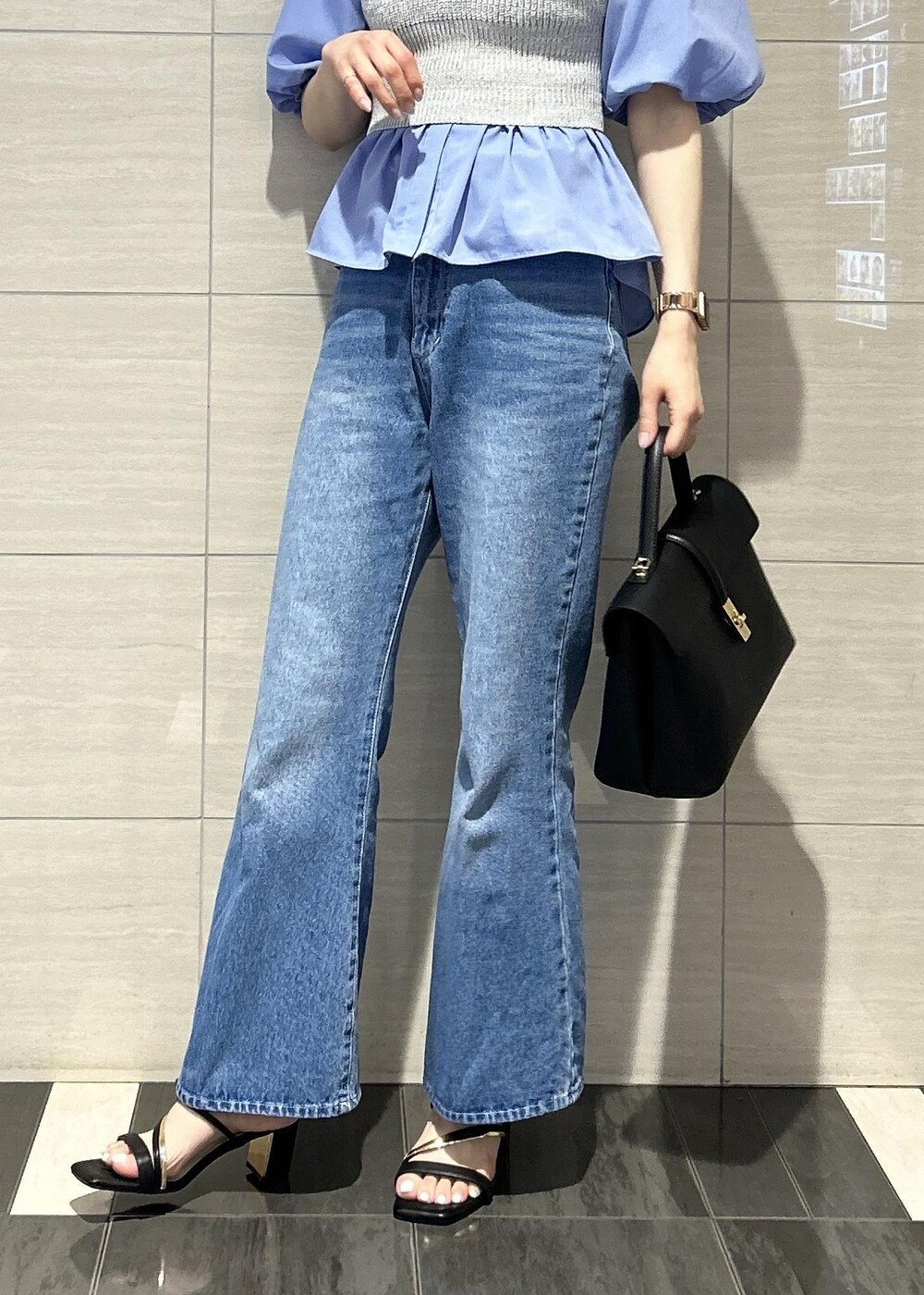 ブラック系のハンドバッグ、ブルー系のデニムパンツ、ブラック系のサンダルを着用したレディースの春コーディネートの9枚目の写真