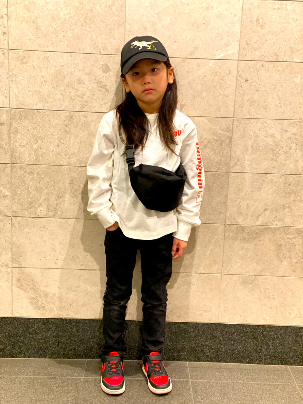 ブラック系のデニムパンツ、ホワイト系のTシャツ/カットソー、レッド系のスニーカーを着用したキッズの春コーディネートの2枚目の写真