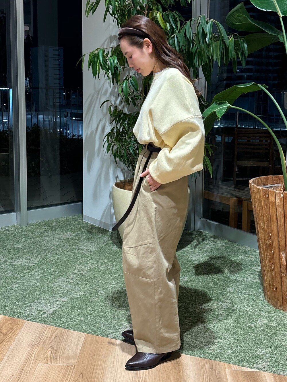 ベージュ系のチノパンツ、ブラウン系のブーツ、イエロー系のニット/セーターを着用したレディースの冬コーディネートの2枚目の写真