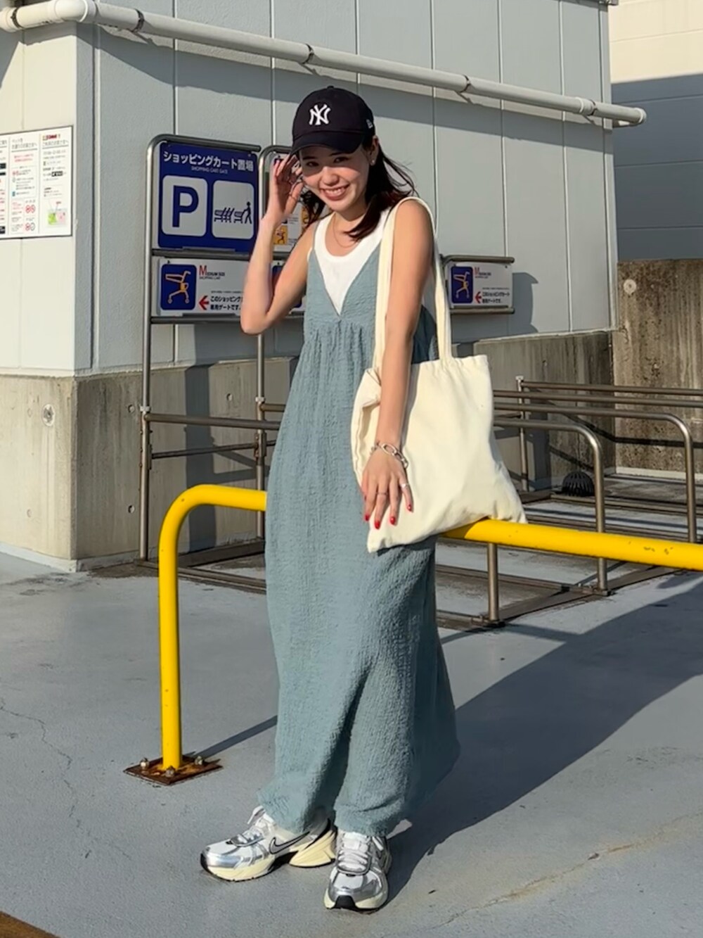 ホワイト系のタンクトップ、ブルー系のワンピース、ホワイト系のスニーカーを着用したレディースの春コーディネートの3枚目の写真