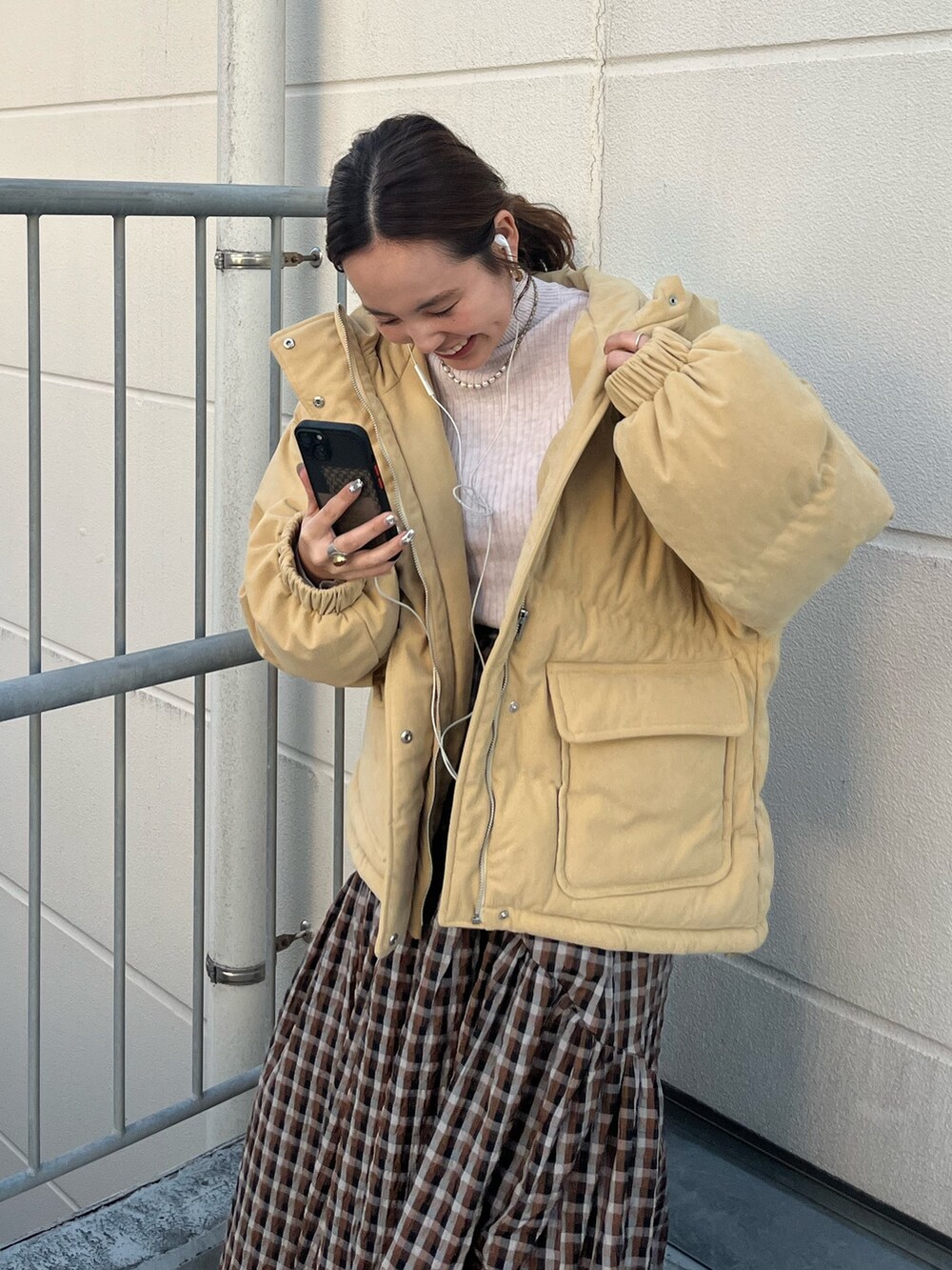 ホワイト系のブルゾン、ホワイト系のニット/セーター、ブラウン系のスカートを着用したレディースの冬コーディネートの3枚目の写真