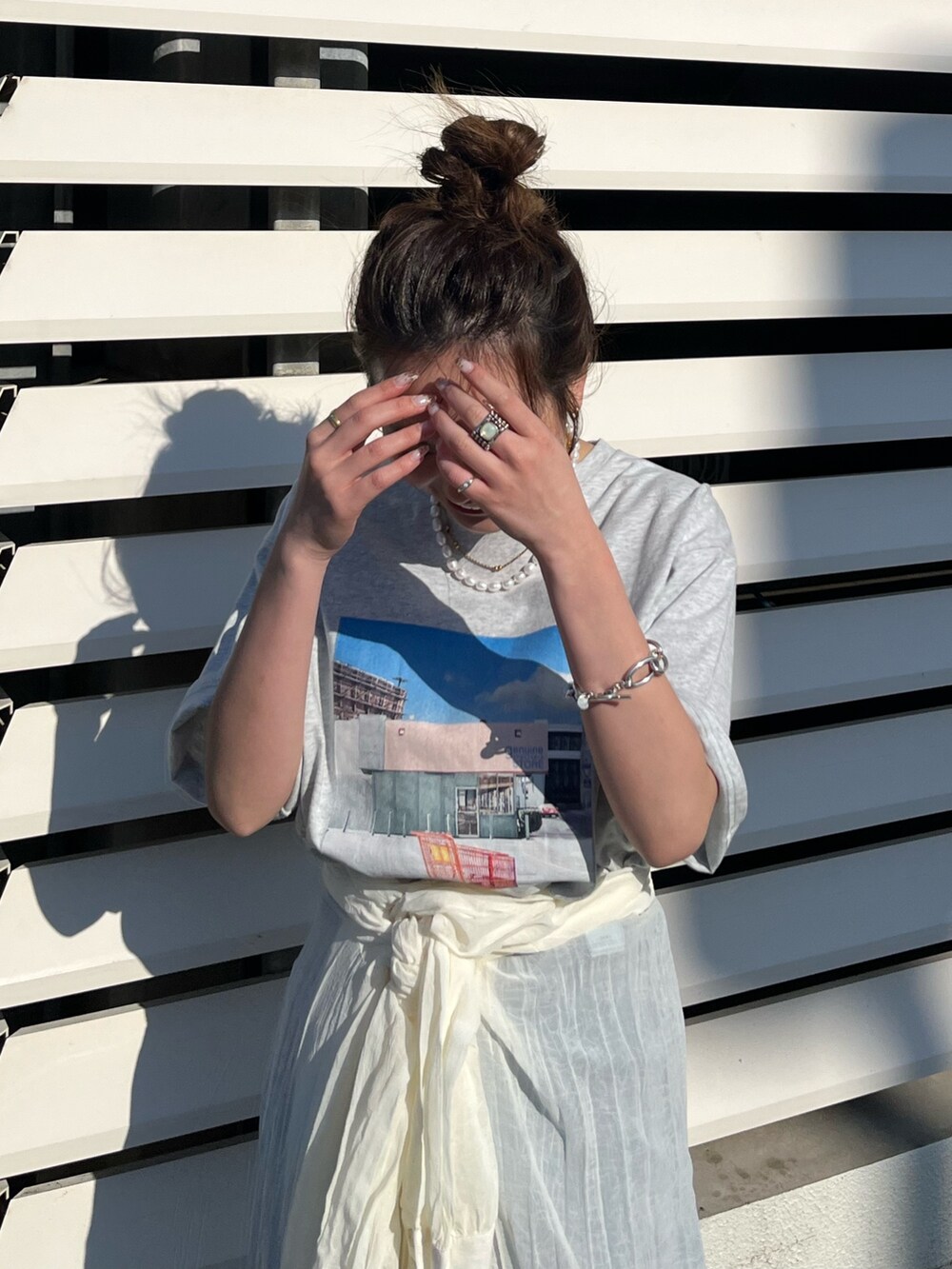 ホワイト系のワンピース、オレンジ系のTシャツ/カットソーを着用したレディースの春コーディネートの2枚目の写真