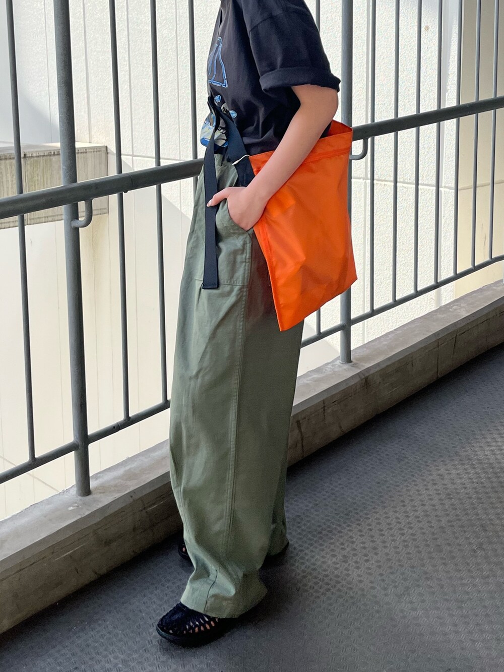 グレー系のTシャツ/カットソー、ベージュ系のその他パンツ、オレンジ系のハンドバッグを着用したレディースの春コーディネートの3枚目の写真