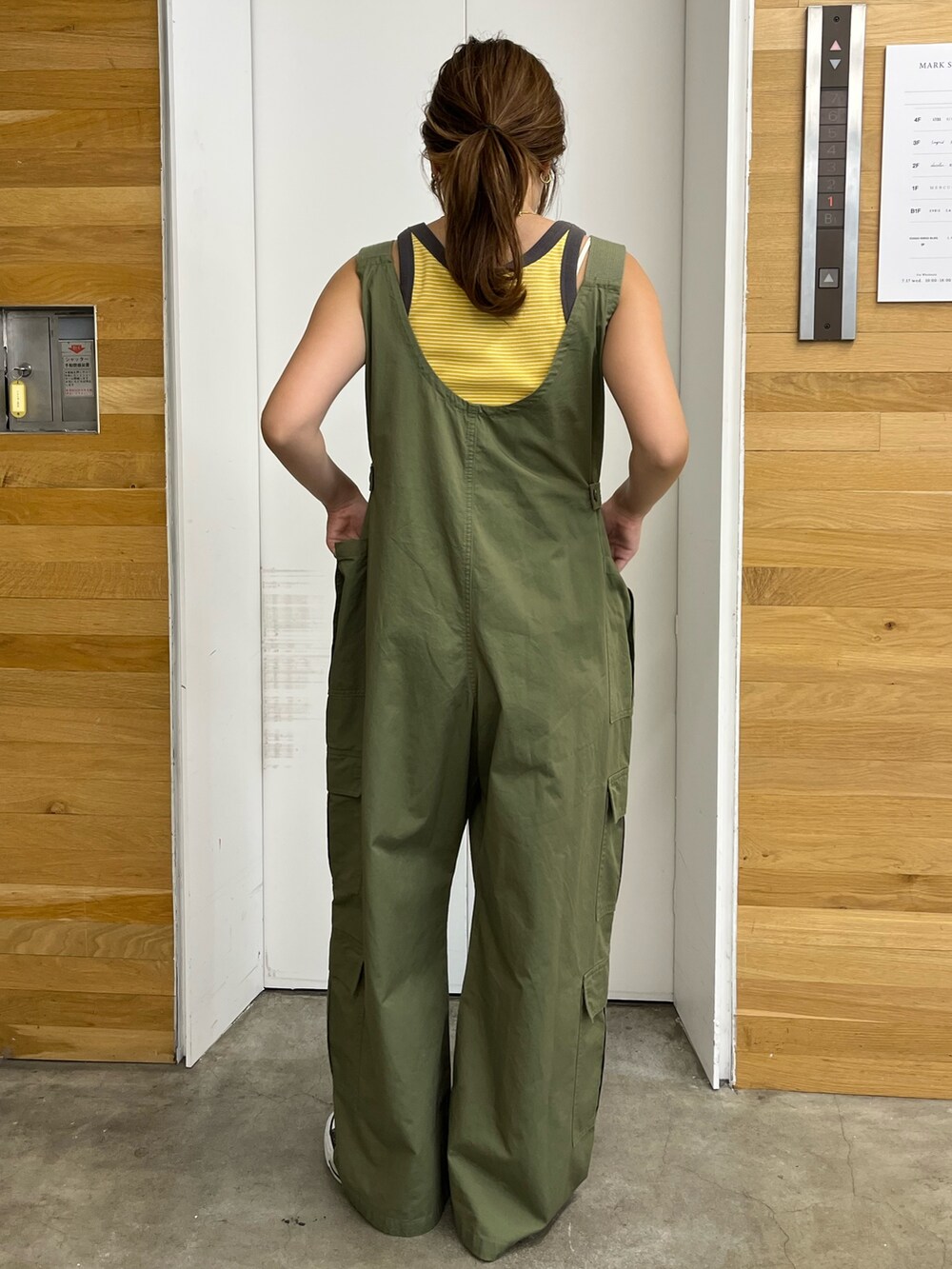 グリーン系のサロペット/オーバーオール、イエロー系のタンクトップを着用したレディースの夏コーディネートの3枚目の写真