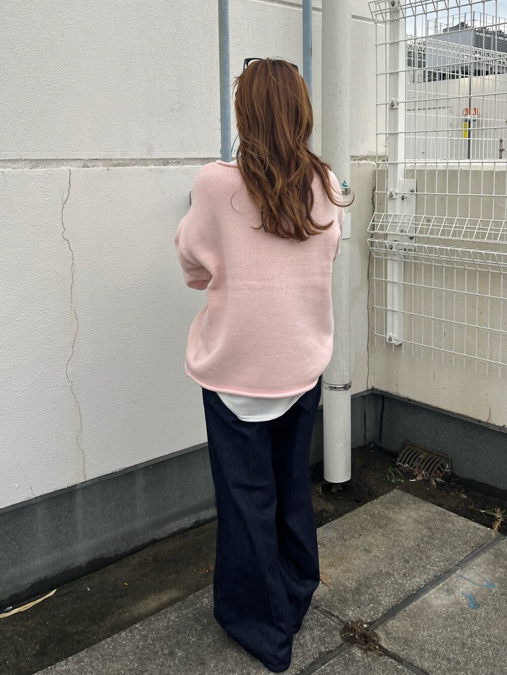 ピンク系のニット/セーター、ブルー系のデニムパンツを着用したレディースの秋コーディネートの3枚目の写真
