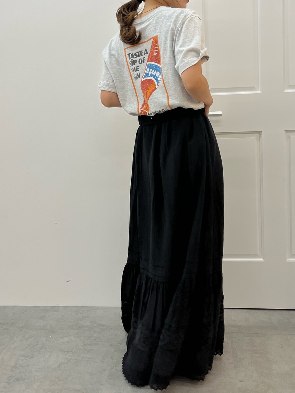 ブラック系のスカート、グレー系のTシャツ/カットソーを着用したレディースの夏コーディネートの3枚目の写真