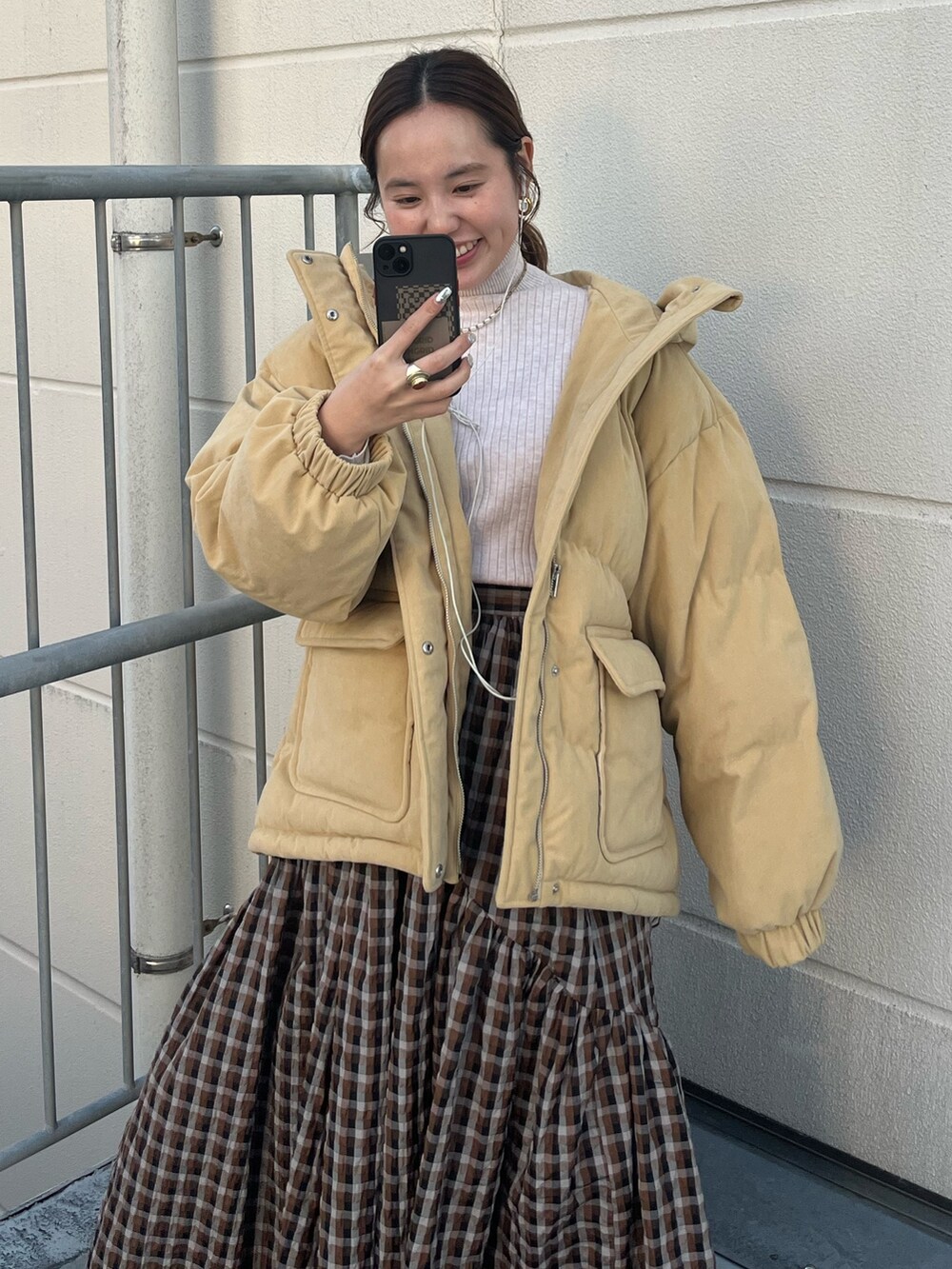 ホワイト系のブルゾン、ホワイト系のニット/セーター、ブラウン系のスカートを着用したレディースの冬コーディネートの2枚目の写真