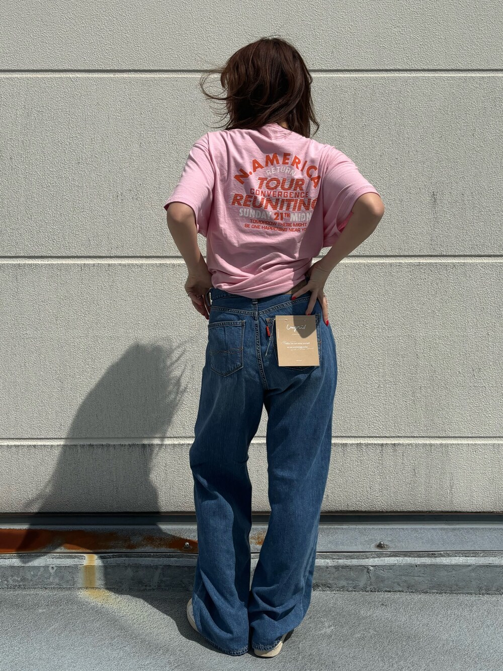 ピンク系のTシャツ/カットソー、ブルー系のデニムパンツを着用したレディースの春コーディネートの3枚目の写真