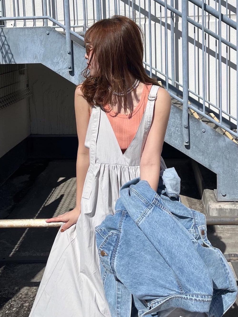 ホワイト系のTシャツ/カットソー、ブルー系のデニムジャケット、ブラック系のワンピースを着用したレディースの春コーディネートの3枚目の写真