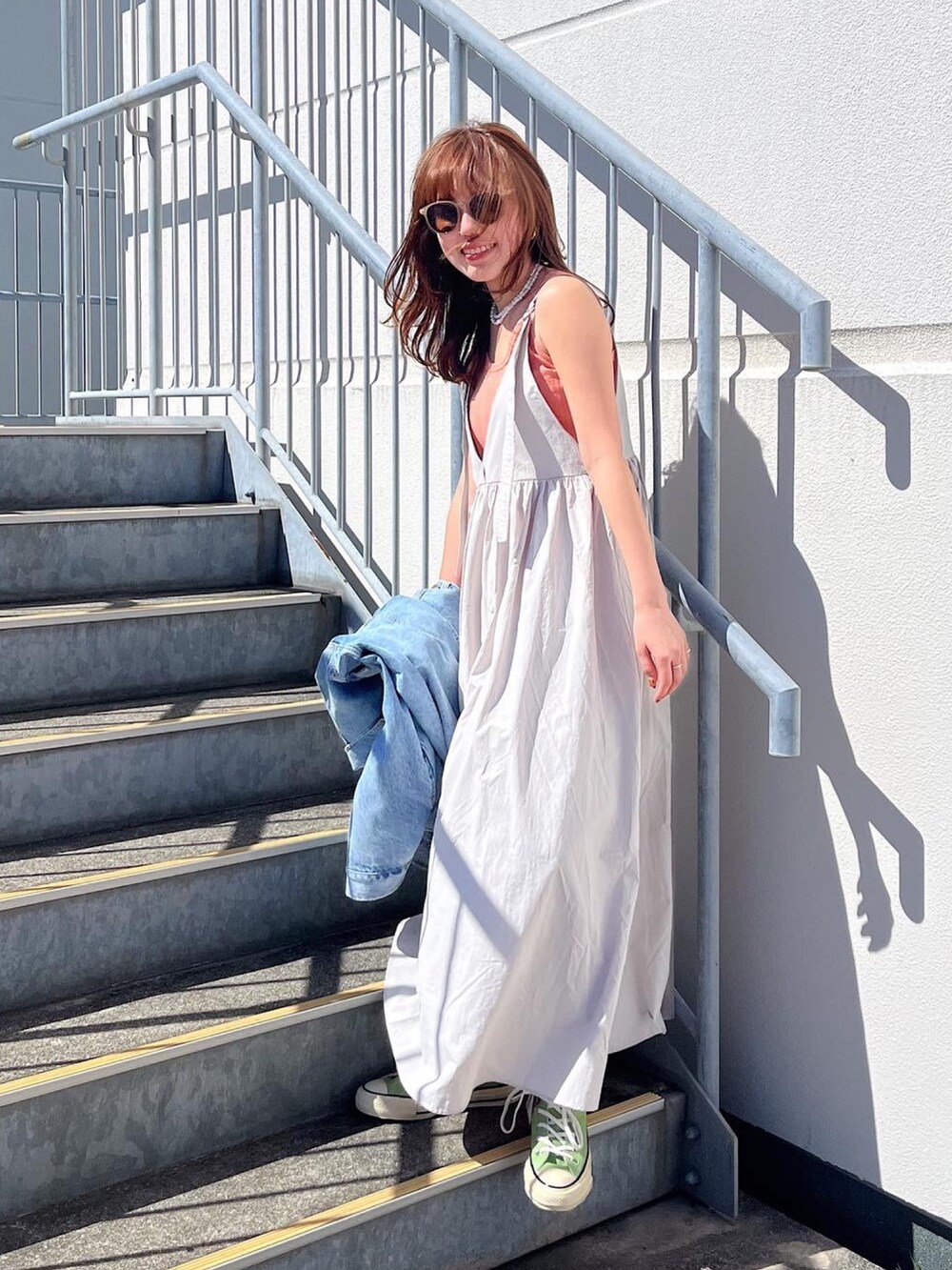 ホワイト系のTシャツ/カットソー、ブルー系のデニムジャケット、ブラック系のワンピースを着用したレディースの春コーディネートの2枚目の写真