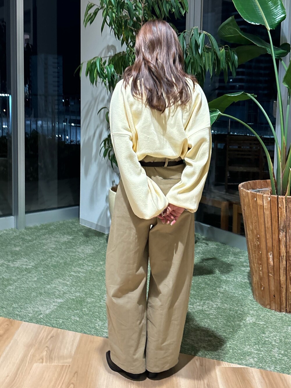 ベージュ系のチノパンツ、ブラウン系のブーツ、イエロー系のニット/セーターを着用したレディースの冬コーディネートの3枚目の写真