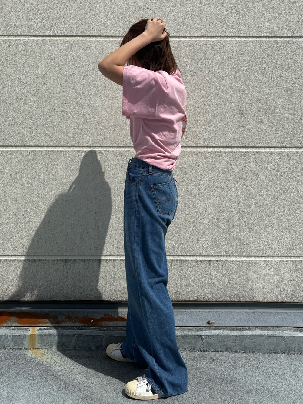 ピンク系のTシャツ/カットソー、ブルー系のデニムパンツを着用したレディースの春コーディネートの2枚目の写真